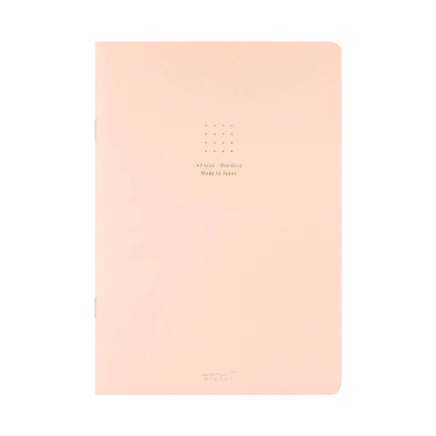 A pastel pink A5 size Dot Grid notebook with gold foil text and a grid pattern on the cover, shown against a plain white background.