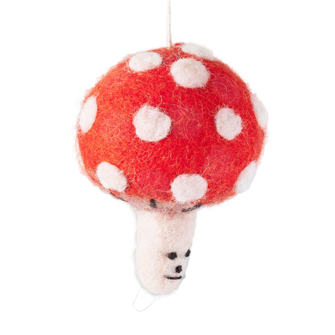 Felted toadstool ornament with white spots on a gray background