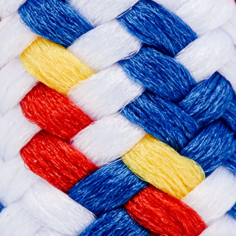 Close-up of a braided or woven textile with alternating thick white, blue, red, and yellow strands, filling the entire frame.