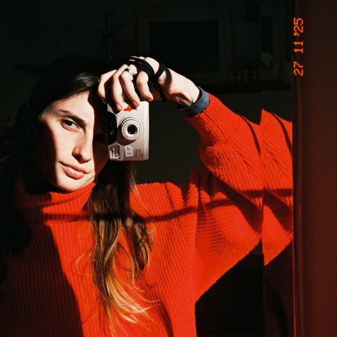 Person taking a photo with a vintage camera in a dark setting