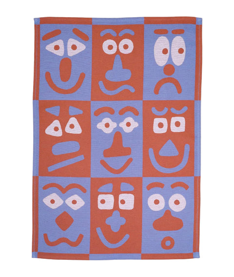 Textile with abstract face designs in red and blue on a white background