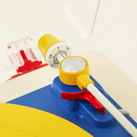 Colorful toy sailboat with a white sail on a light background