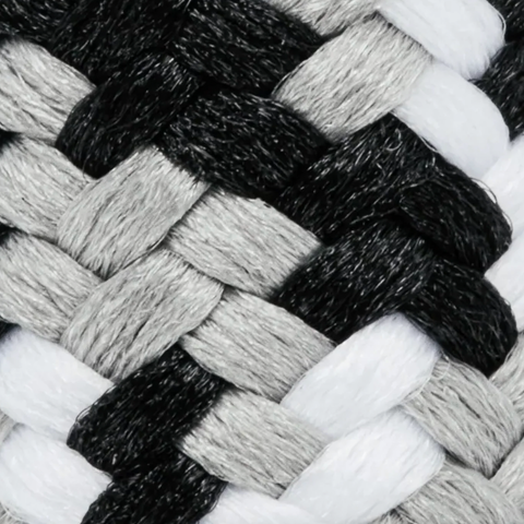 Close-up of a braided or woven textile pattern in black, light gray, and white, showing the texture and color mix of the material.